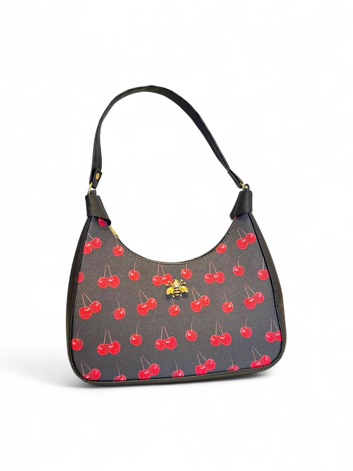 Bolsa tipo hobo con estampado de cerezas, fondo blanco, ribete rojo y herraje dorado con forma de abeja