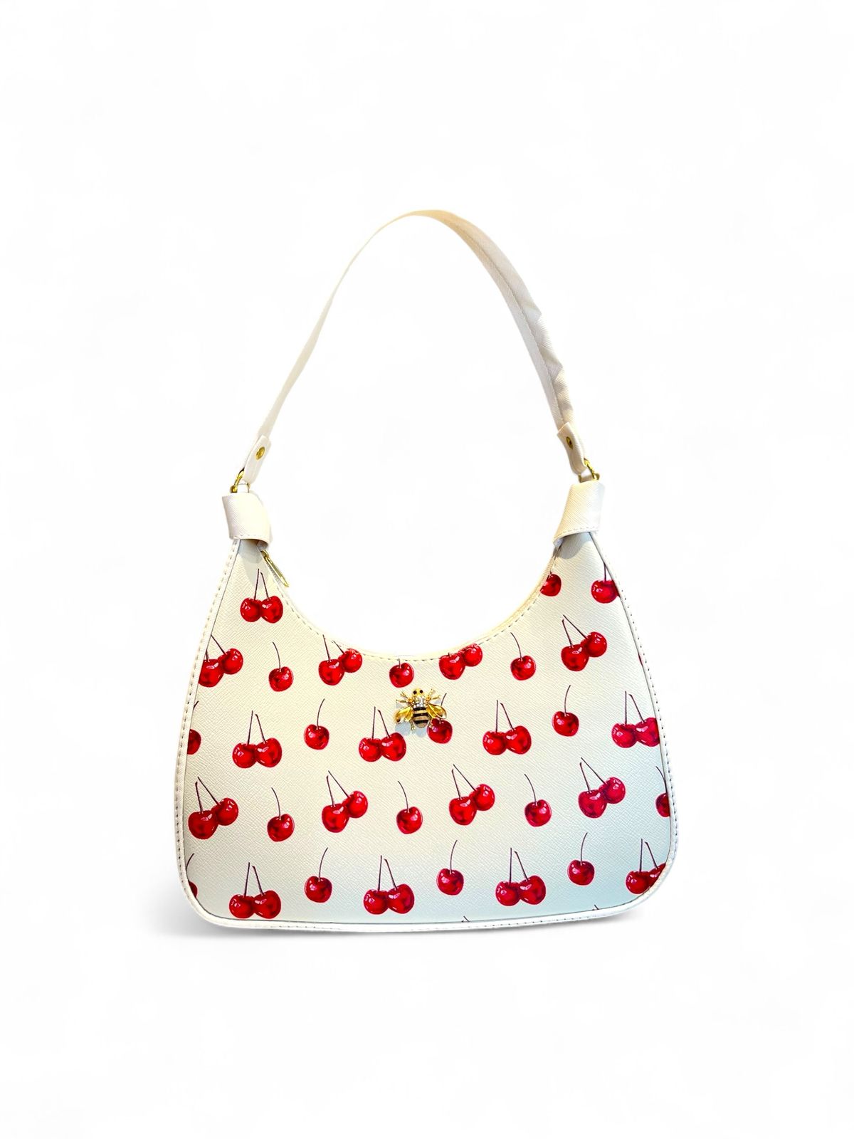 Bolsa tipo hobo con estampado de cerezas, fondo blanco, ribete rojo y herraje dorado con forma de abeja