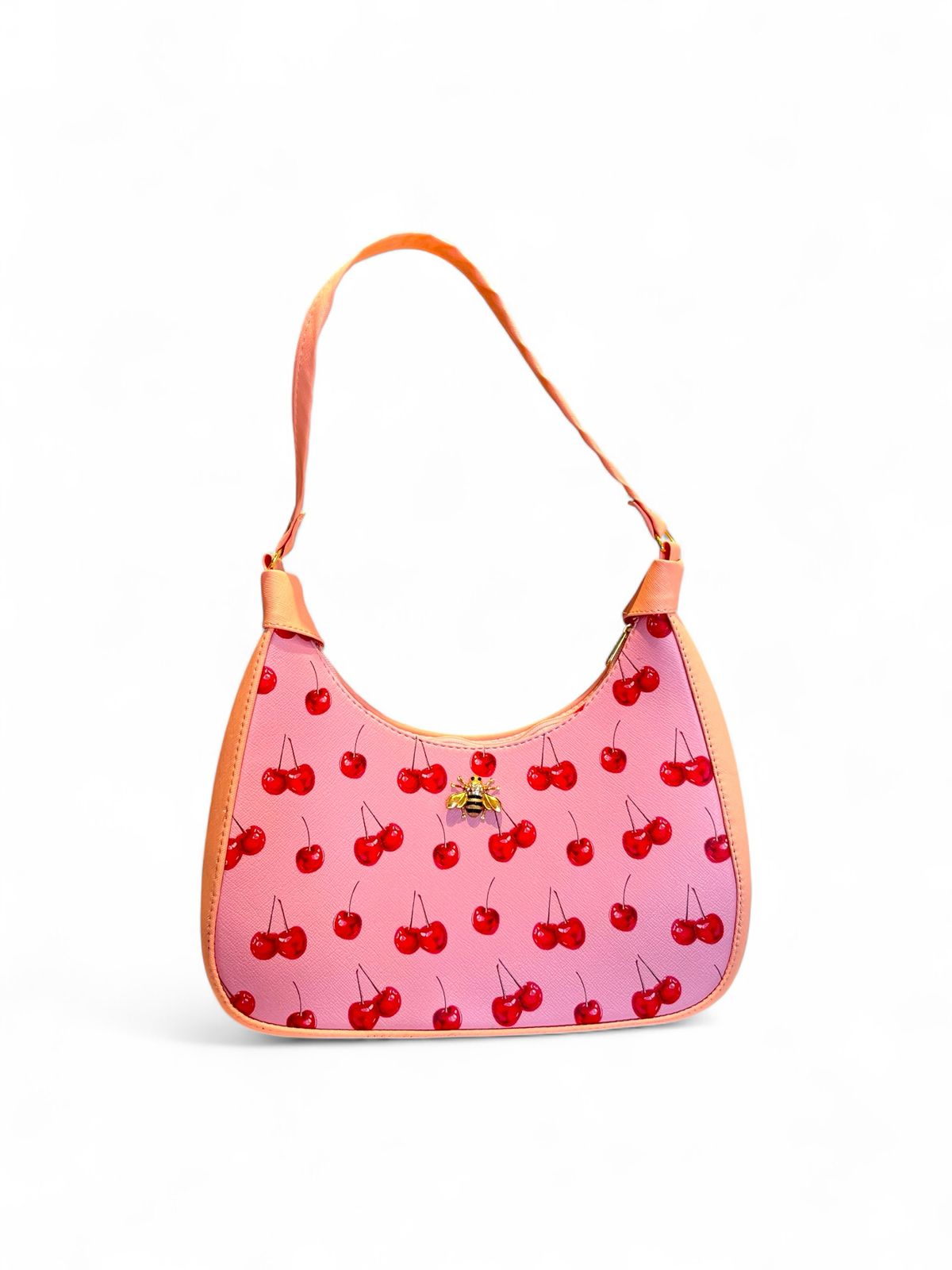Bolsa tipo hobo con estampado de cerezas, fondo blanco, ribete rojo y herraje dorado con forma de abeja
