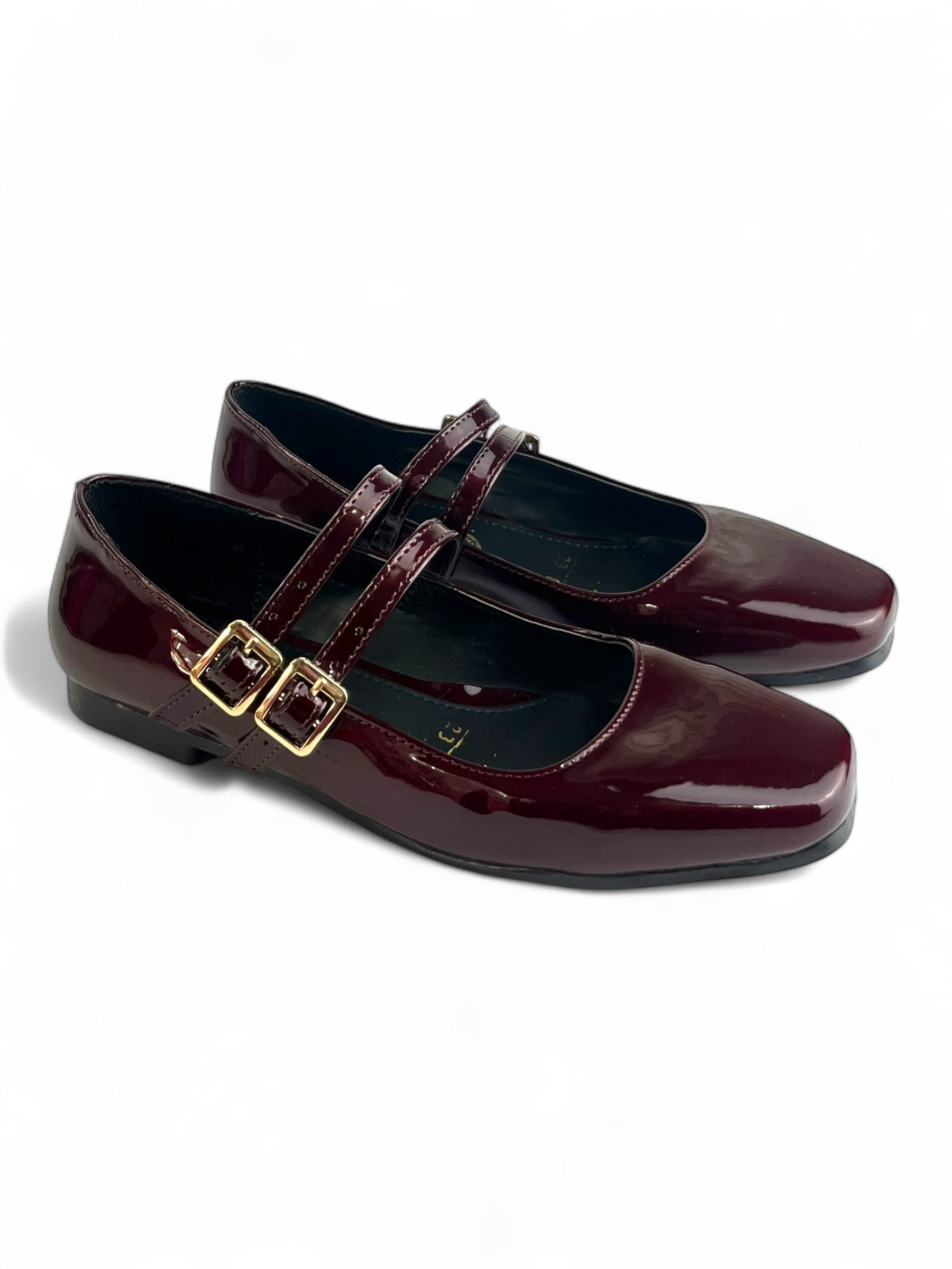 Zapatos Mary Jane de DALALI en color negro tipo charol con doble hebilla dorada y punta cuadrada.