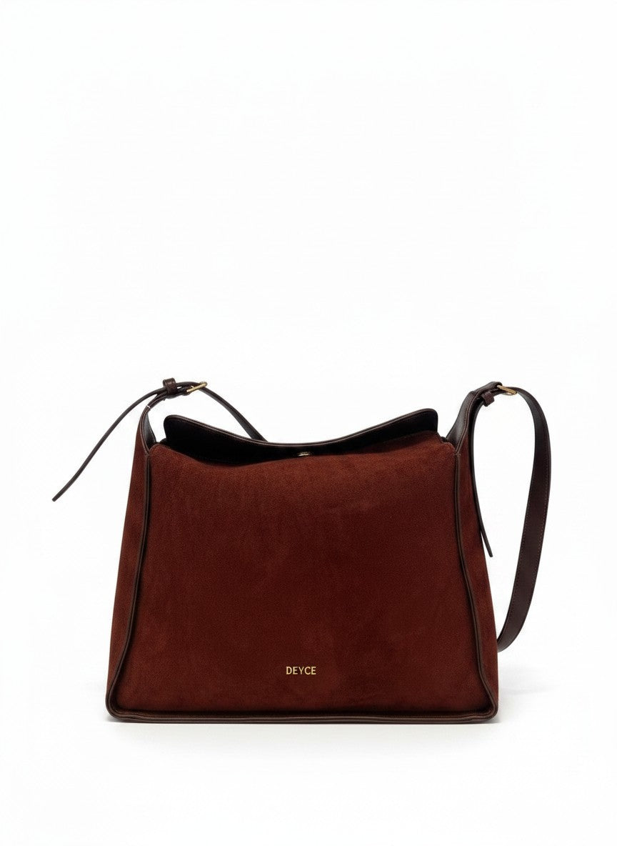 Bolsa crossbody de gamuza sintetica vino con ribete de cuero y herrajes dorados, marca DALALI